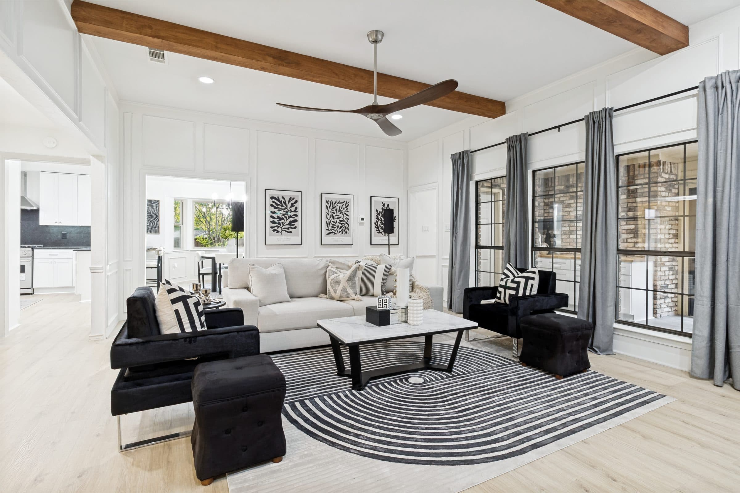 Living room styled in black and white with exposed ceiling beam