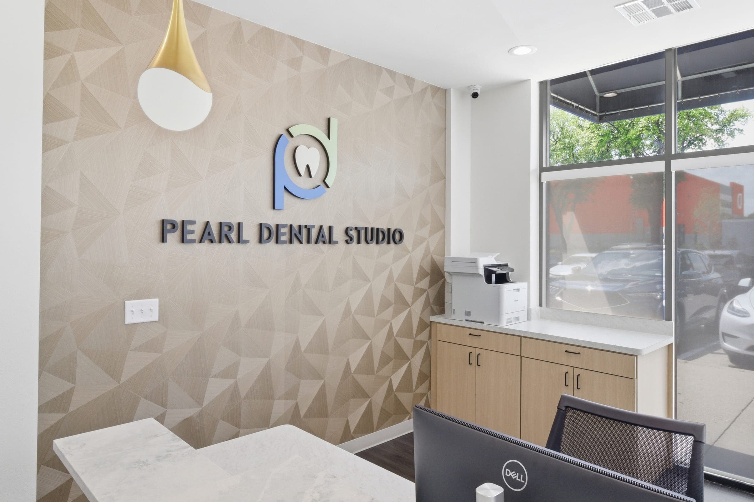 Reception area of a dental studio with branded signage wall