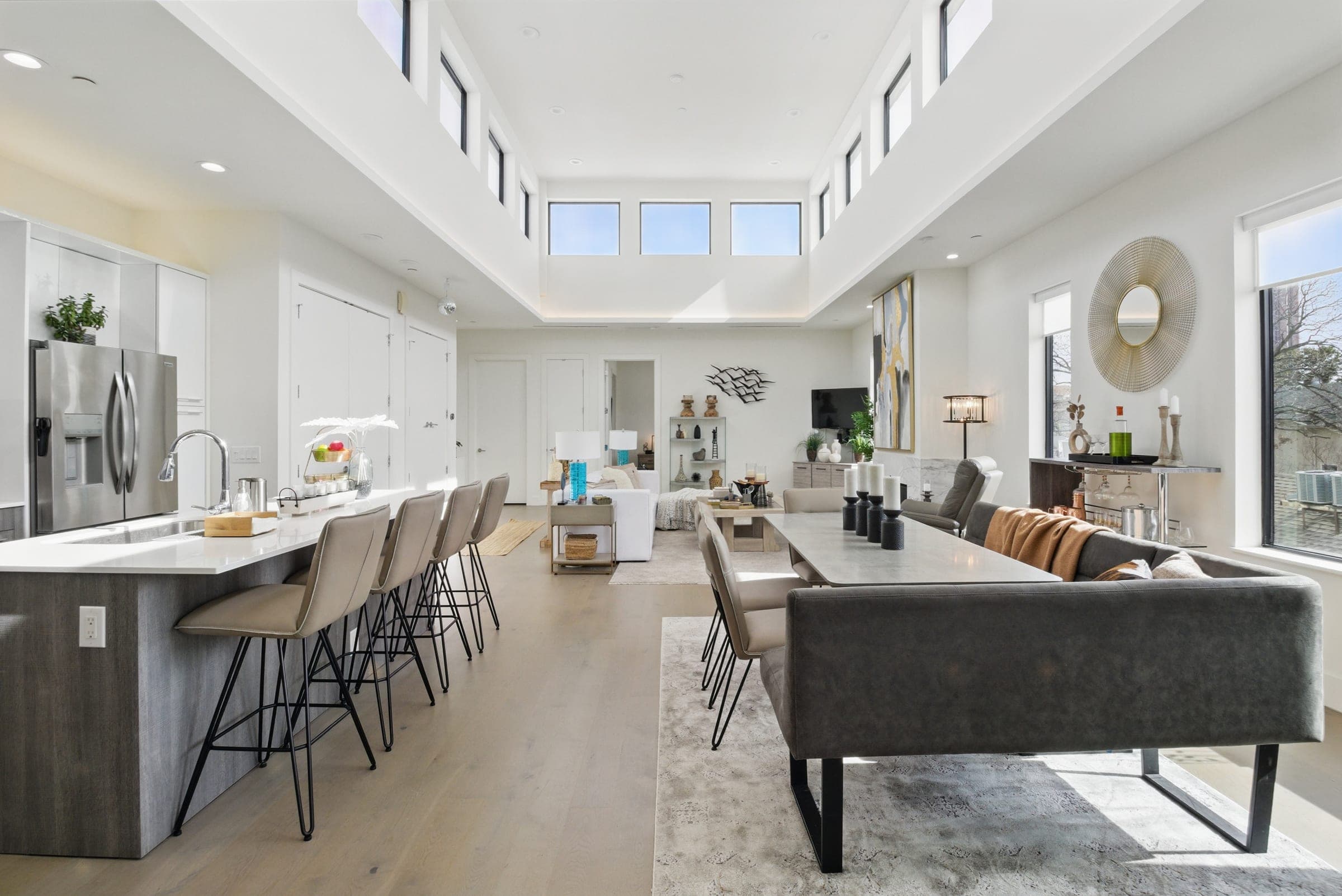 Sunlit open-concept kitchen and living space with double-height windows