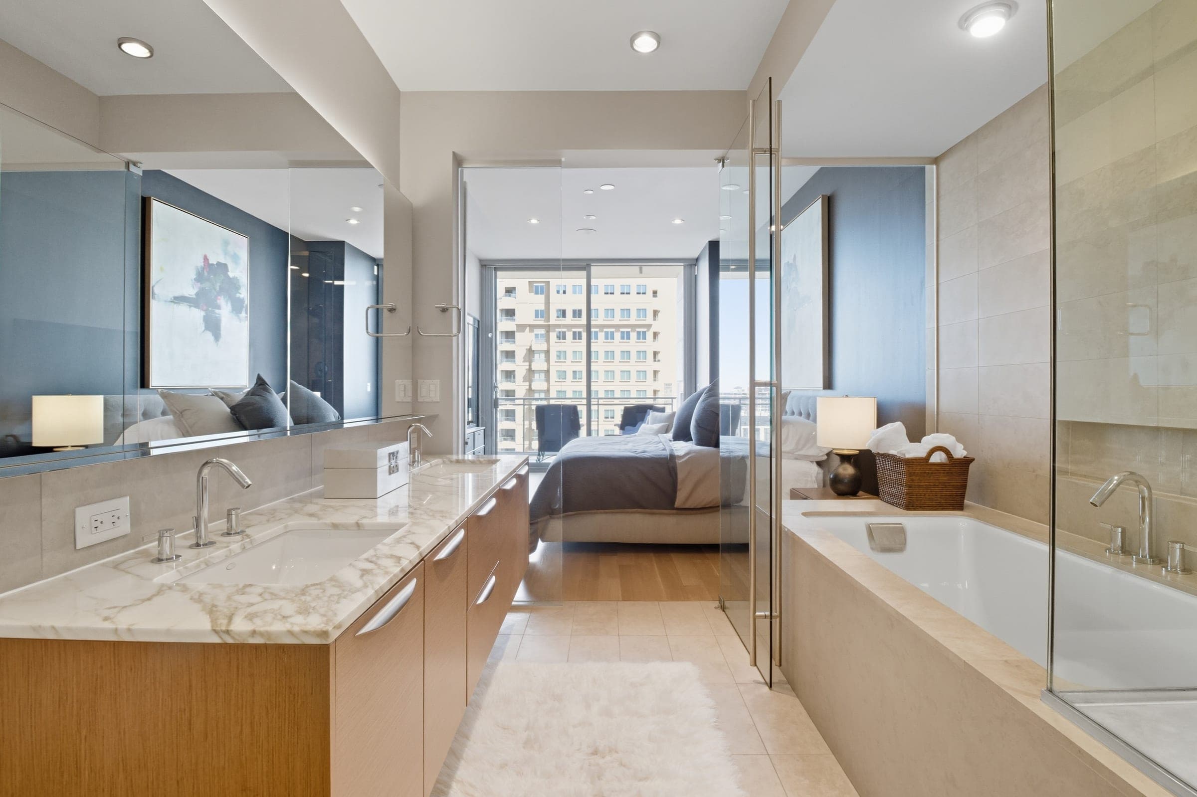 High-rise condominium primary suite with ensuite bath and city view