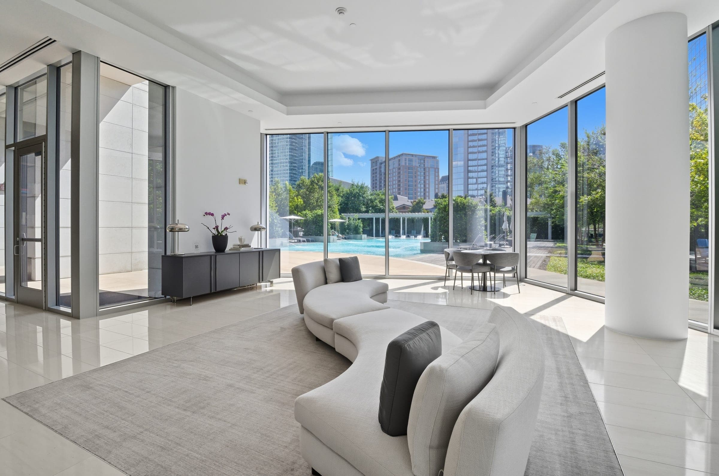 High-rise amenity lounge with floor-to-ceiling windows overlooking a pool and skyline