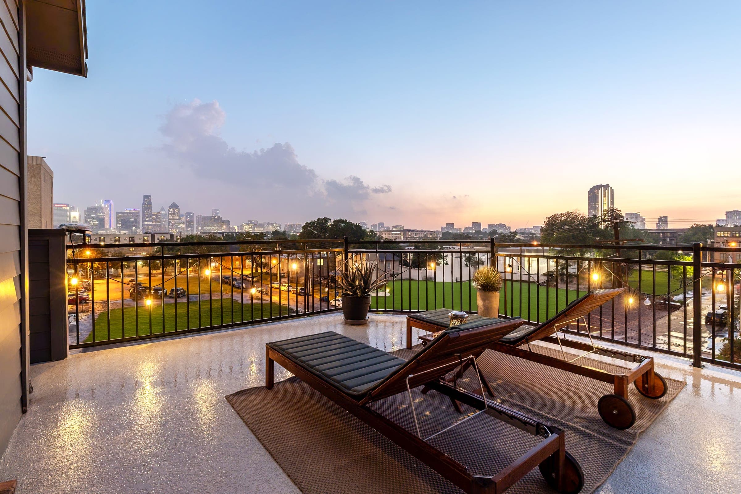 Rooftop balcony lounge chairs overlooking the Dallas skyline at twilight
