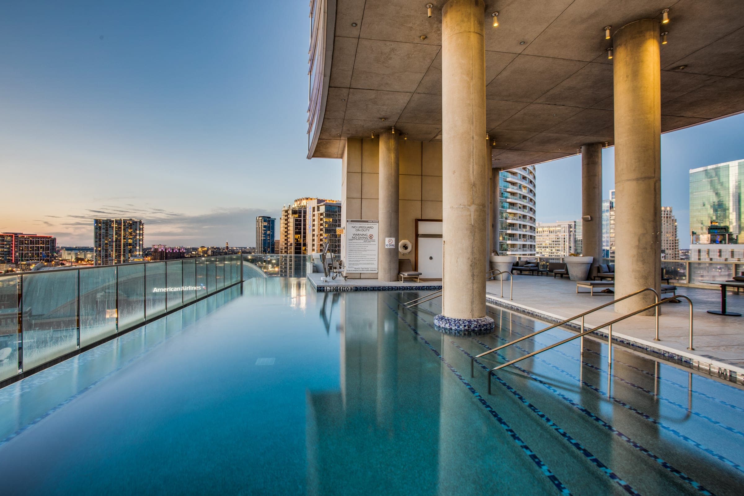 Rooftop infinity pool overlooking the downtown Dallas skyline at dusk